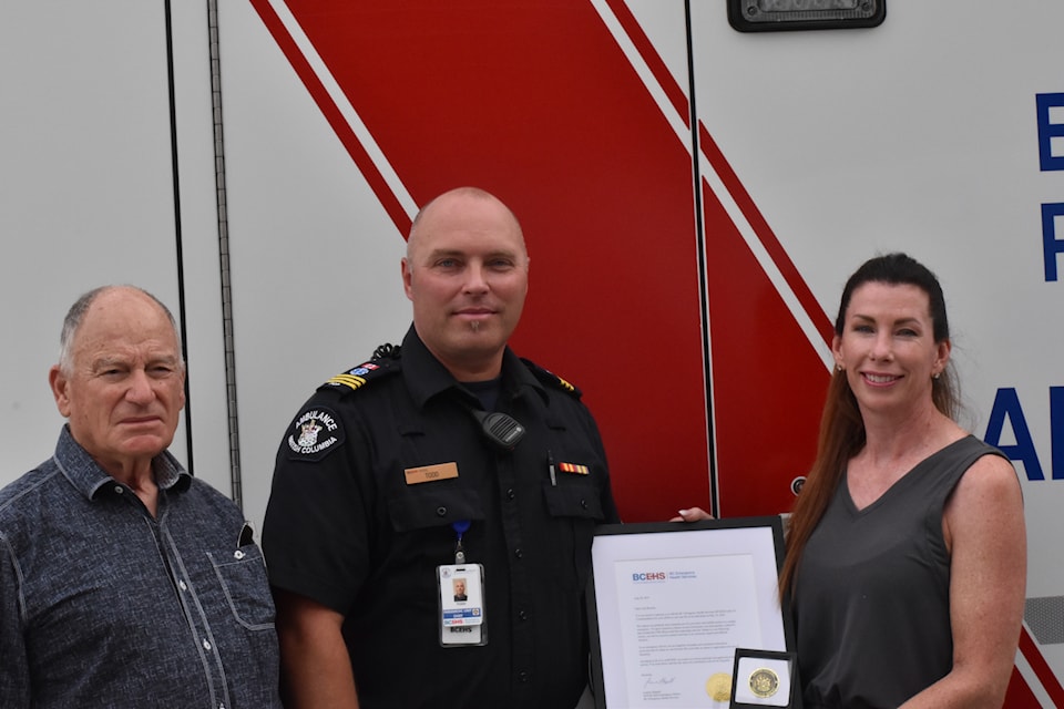 Jody Rausch (right) holds a commendation letter she received from BC Ambulance after helping save Thomas Gee's life (left) at an Osoyoos gym in May 2025. In middle: Todd Kunz, unit chief at Osoyoos' ambulance station.