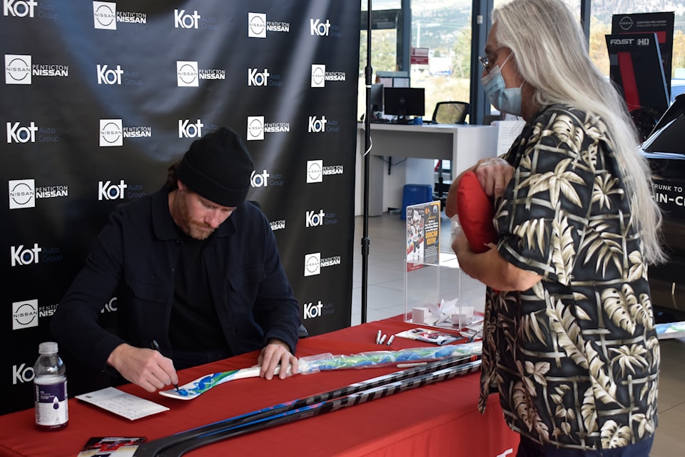 Three-time Stanley Cup champion Duncan Keith signs a fan's hockey stick at Penticton Nissan on Saturday, Oct. 5, 2024.