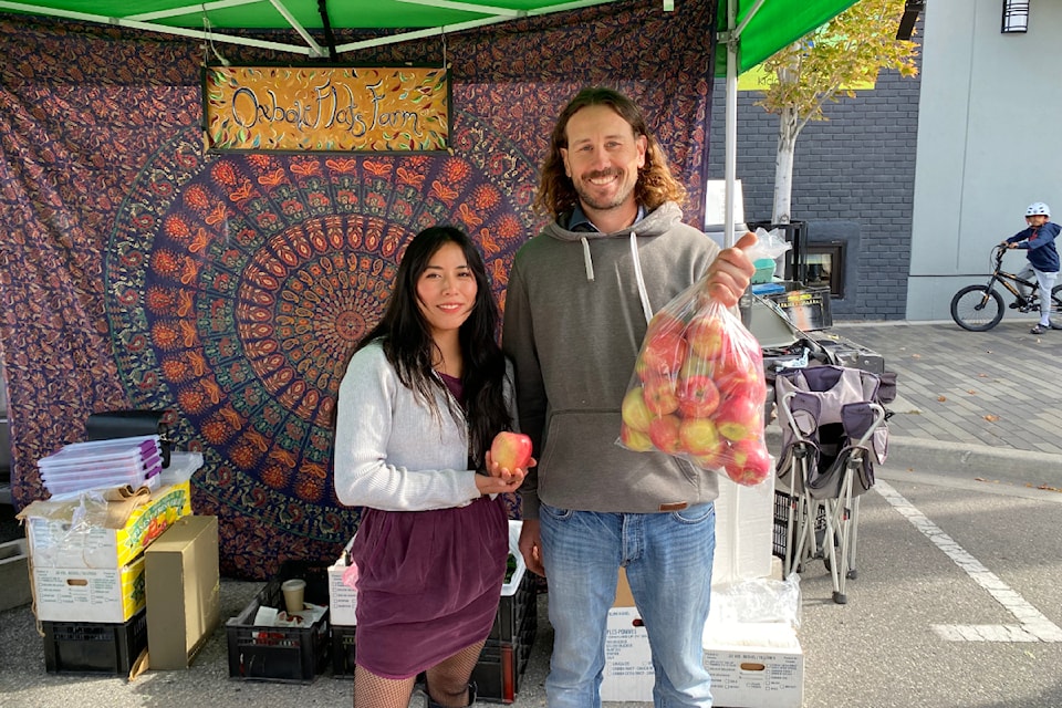 Oliver's Oxbox Flat Farm holding their locally grown apples at the Penticton Farmers' Market on Saturday, Sept. 28, 2024.