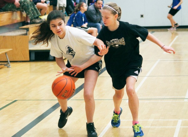KVR's Marrisa X bounces around McNicoll's Lyn X during Grade 7 basketball...