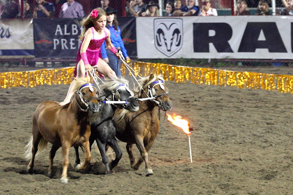 Nine-year-old Pipe Yule drivers her ponies around sticks of fire in the Armstrong Rodeo grounds during the IPE. (Jennifer Smith - Morning Star)