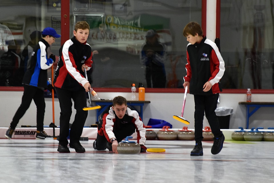 Team Tomlinson’s Ryan Cowell throws his rock while Nolan and Kaiden Beck get ready to sweep on Saturday in Penticton. (Brennan Phillips - Western News)
