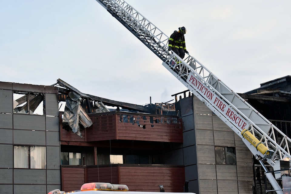 A firefighter descends the ladder truck after checking on the upper floors of the Clarence House apartment building after a fire broke out Tuesday morning. See story on page 5. (Brennan Phillips - Western News)