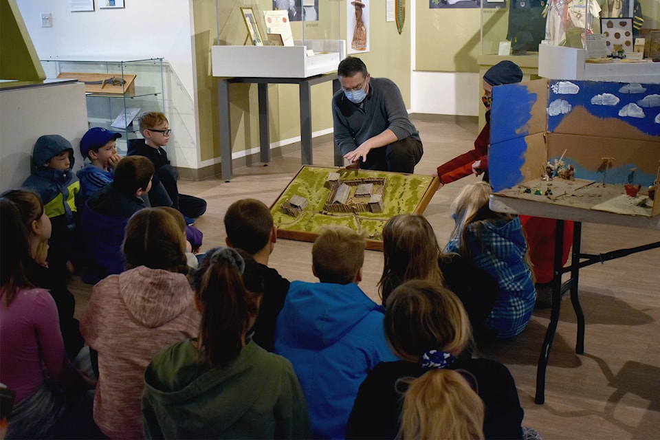 Penticton Museum curator Dennis Oomen on Dec. 4 showing students from Uplands Elementary School the diorama he had built for the fur trade for a previous museum. (Brennan Phillips - Western News)