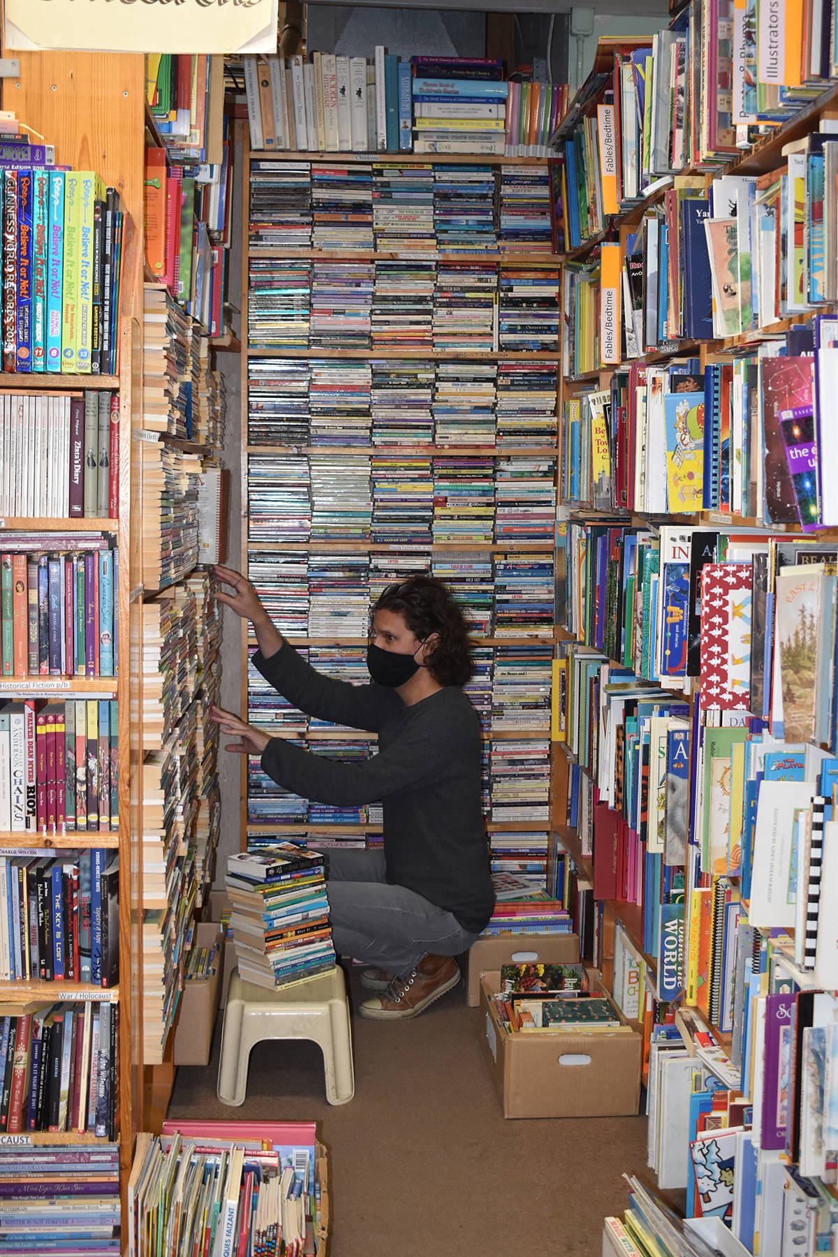 Tavis Stevenson puts away books in the childrens section of The Book Shop on Main St. The pandemic has hurt the iconic independepent book shop like so many other local businesses. (Monique Tamminga Western News)