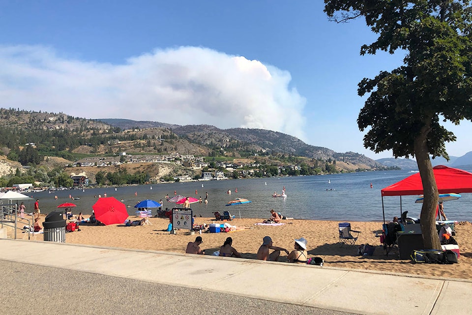 As beach-goers enjoy Skaha Lake, a wildfire rages out of control near OK Falls Sunday afternoon. (Monique Tamminga Western News As beach-goers enjoy Skaha Lake, a wildfire rages out of control near OK Falls Sunday afternoon. (Monique Tamminga Western News)