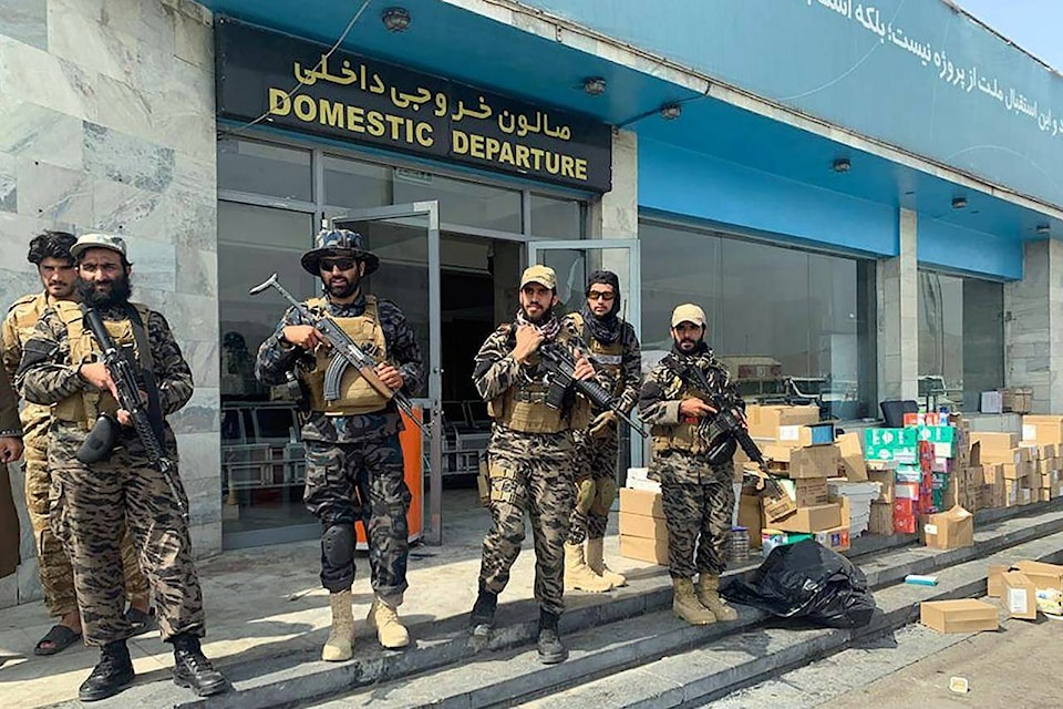 FILE - In this Aug. 31, 2021 file photo, Taliban fighters stand guard inside the Hamid Karzai International Airport after the U.S. withdrawal in Kabul, Afghanistan. Taliban authorities will allow between 100 and 150 Americans to fly out from Kabul in the coming hours, Qatari officials said on Thursday, Sept. 9, 2021, marking the airport’s first such flight since U.S. forces withdrew from the country. The large group of foreigners, including Americans and other Westerners, would depart Thursday on a Qatar Airways flight that had earlier ferried humanitarian aid to the country, officials said. (AP Photo/Kathy Gannon, File)