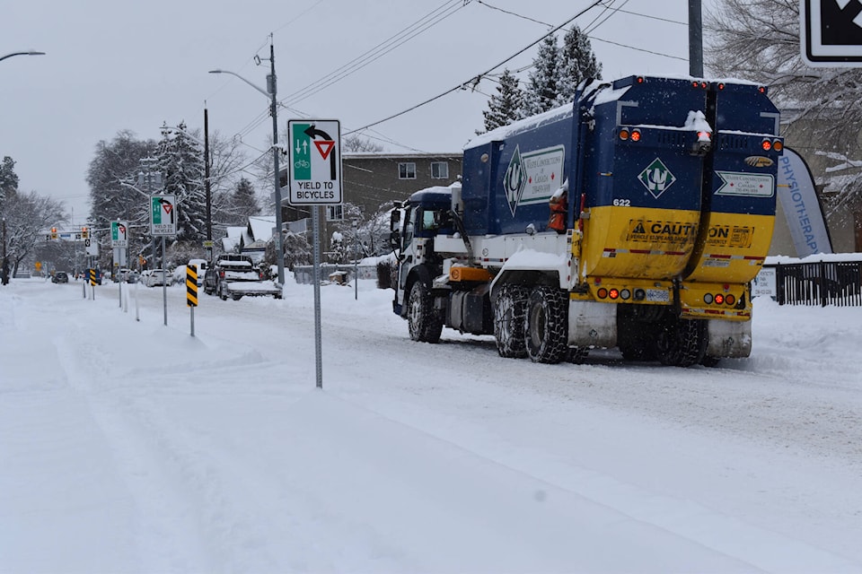 A garbage trucks drives on Martin Street beside the bike lanes on a snowy Dec. 6. (Brennan Phillips Western News)