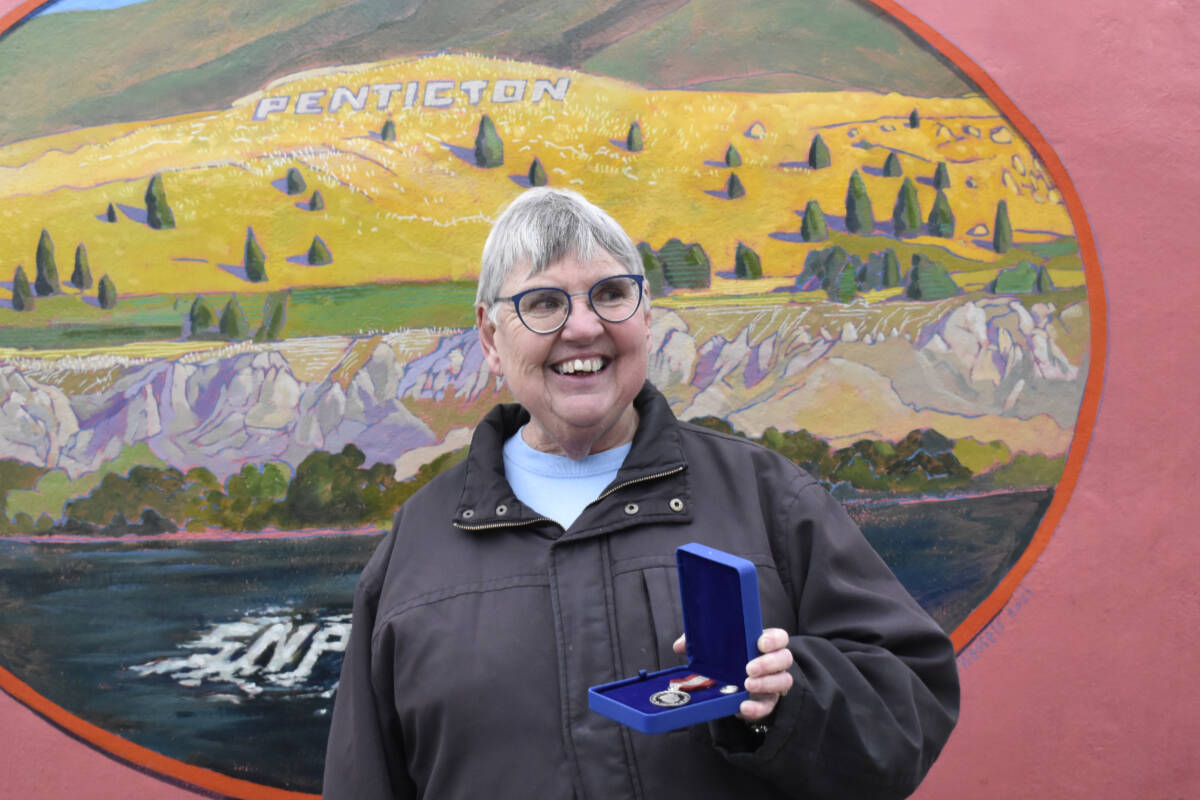 Roni Keeley pictured with her Sovereigns Medal for Volunteers award in front of Pentictons iconic Peach concessions stand. (Logan Lockhart, Western News)