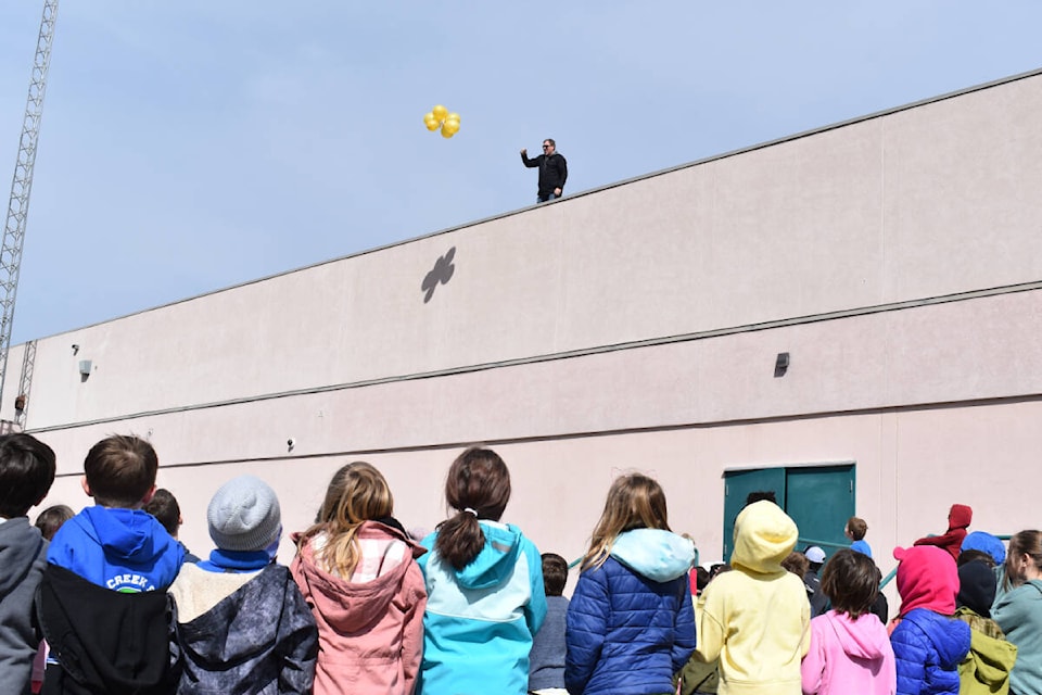 Trout Creek Grade 5 teacher Brian Hutcheson throws one of the egg contraptions off the roof of the school during the annual egg launch held April 14. (Monique Tamminga Western News)