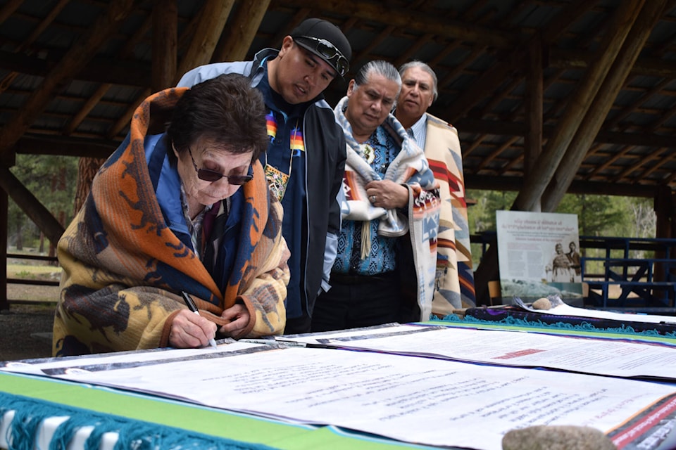 Elaine Emerson signs the Ashnola Indigenous Protected and Conserved Area declaration as a witness. LSIB Councillor Ira Edward, and witnesses Andrew Joseph Junior and Dan Wilson wait for their turn to sign on April 28. (Brennan Phillips - Keremeos Review)