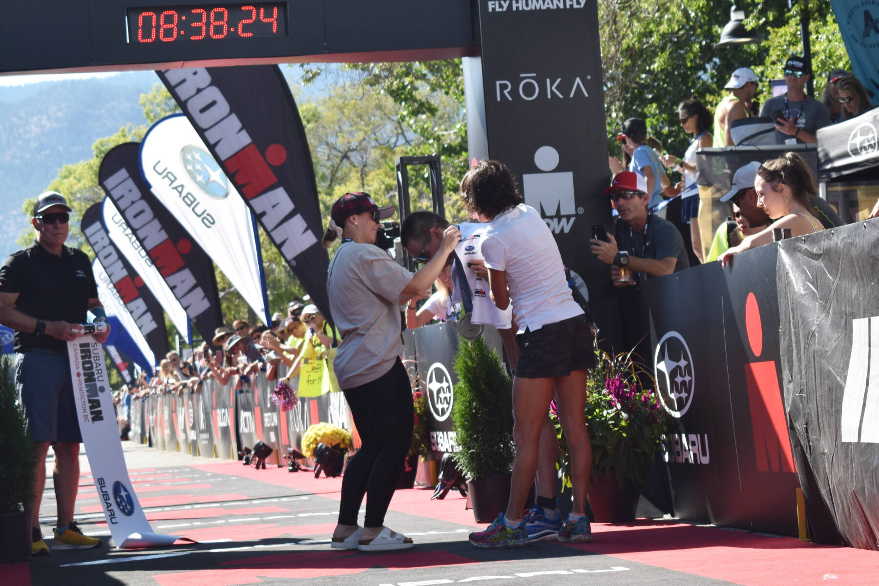 Ironman Penticton winner Jeff Symonds wife puts a medal around his neck at the finish line on Sunday. (Brennan Phillips Western News)