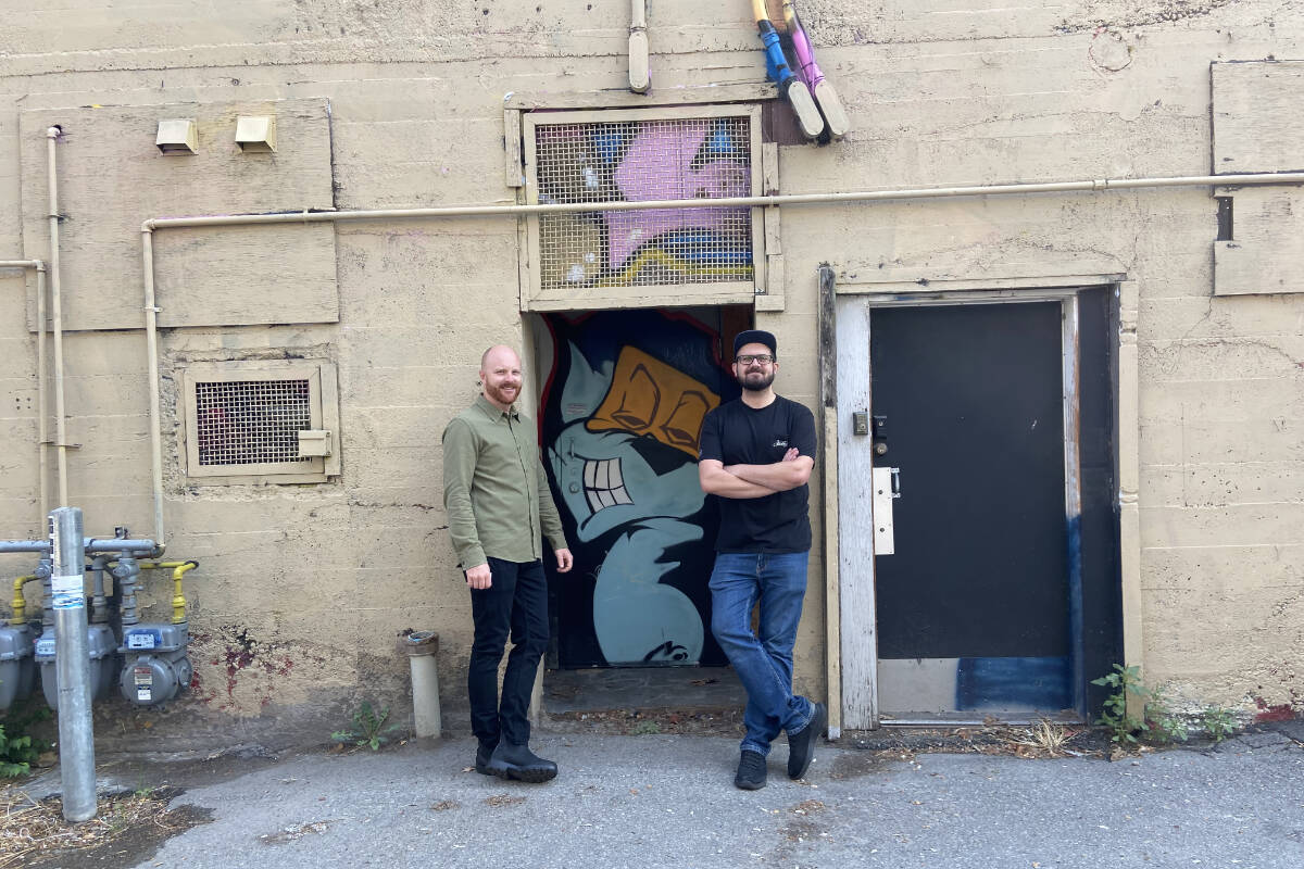 Downtown Penticton executive director Brett Turner stands with Liam Peyton in the alley behind Slackwater Brewing. The drab, unfriendly alley is getting a vibrant paint job and full transformation and there is a celebration to go with it on Sept. 25. (Monique Tamminga Western News)