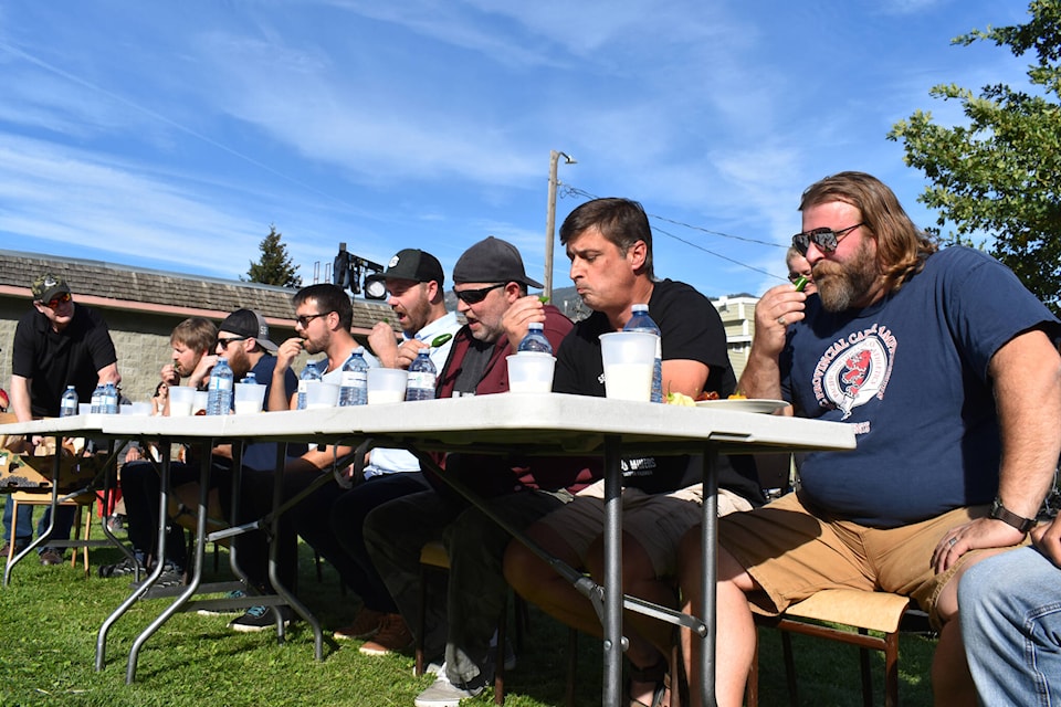 Competitors chow down on a jalapeno, the coolest of five peppers, at the Similkameen Sizzlefest. The ghost pepper was only the second-hottest pepper of the day. (Brennan Phillips - Review)