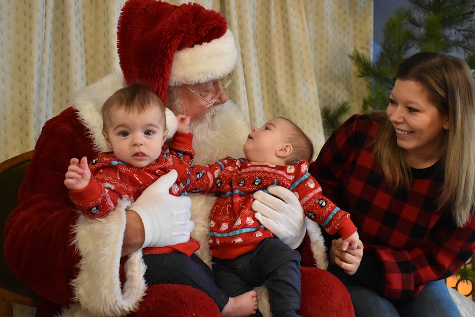 Santa Gary Haupt has some fun with seven-month old twins Isabella and Emilia at the Mamas For Mamas Penticton fundraiser at Slackwater Brewing on Monday. (Monique Tamminga Western News)