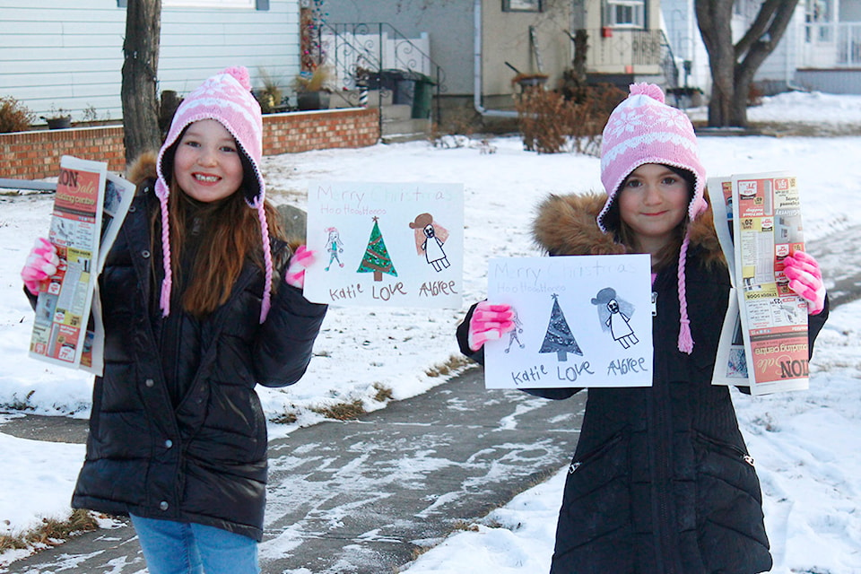 Katie Hodges, left, and Aubree Reynolds hold up one of the pictures they made and delivered during Christmas time. (Emily Jaycox/Ponoka News)