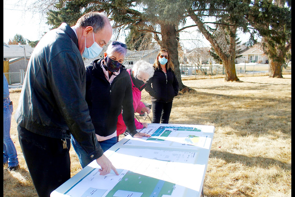 Jim Hamilton looks over the preliminary design with seniors who came out to the public meeting on March 12. (Emily Jaycox/Ponoka News)