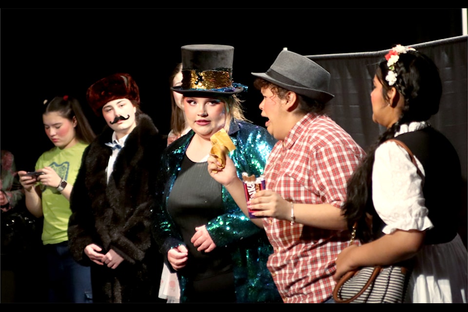 Willy Wonka (Ava Morency, Grade 11) takes the golden ticket from Augustus Gloop (Jenny Burns, Grade 11).