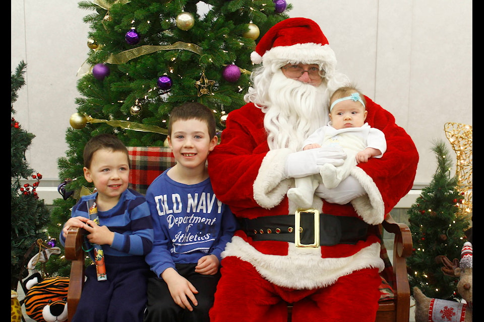 Bauer, Xander and Disney Wilson (three, six and three months old) get their photo taken with Santa.