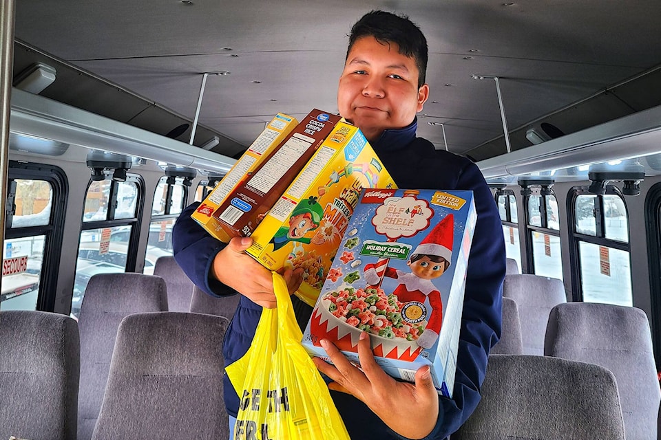 Blaze Rain holds some of the donated food items while the bus is loaded Dec. 14. St. Augustine School’s “Pack the Bus” campaign on Dec. 14, 2021 brought in a total of 1,769 lbs of donated food items. The total cash donations recevied has not been totaled yet. The high school students organized a school-wide food bank drive. Each class took a turn brining their donation items to the bus and loading them on. (Photos submitted/Dustin Ellingson)
