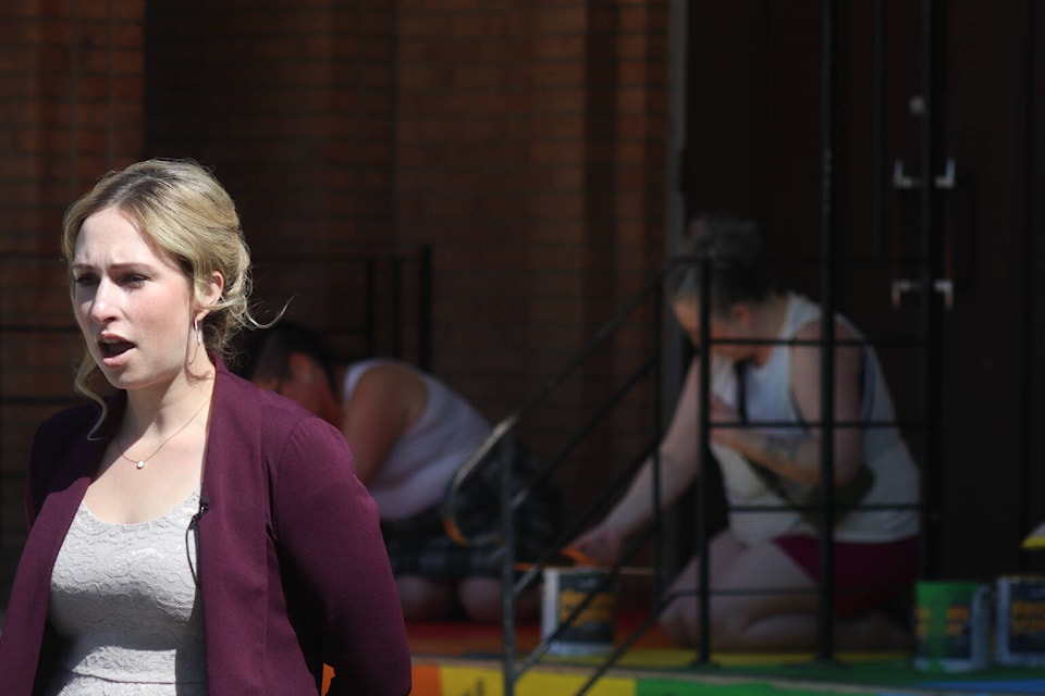 Jessica Jones speaks in front of the Ponoka United Church on June 2, as volunteers repaint the rainbow step in the background. (Photos Emily Jaycox/Ponoka News)