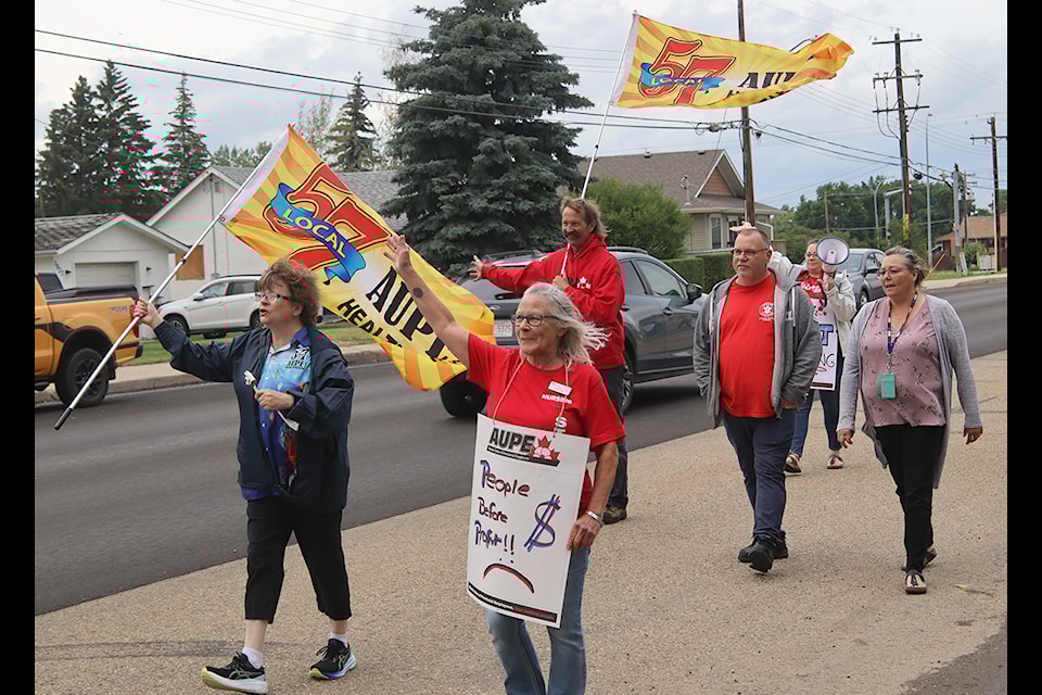 Signs saying "We Support Public Services" were displayed during an AUPE rally in Ponoka on July 25. One participant's sign read "Working for peanuts in a peanut-free zone."