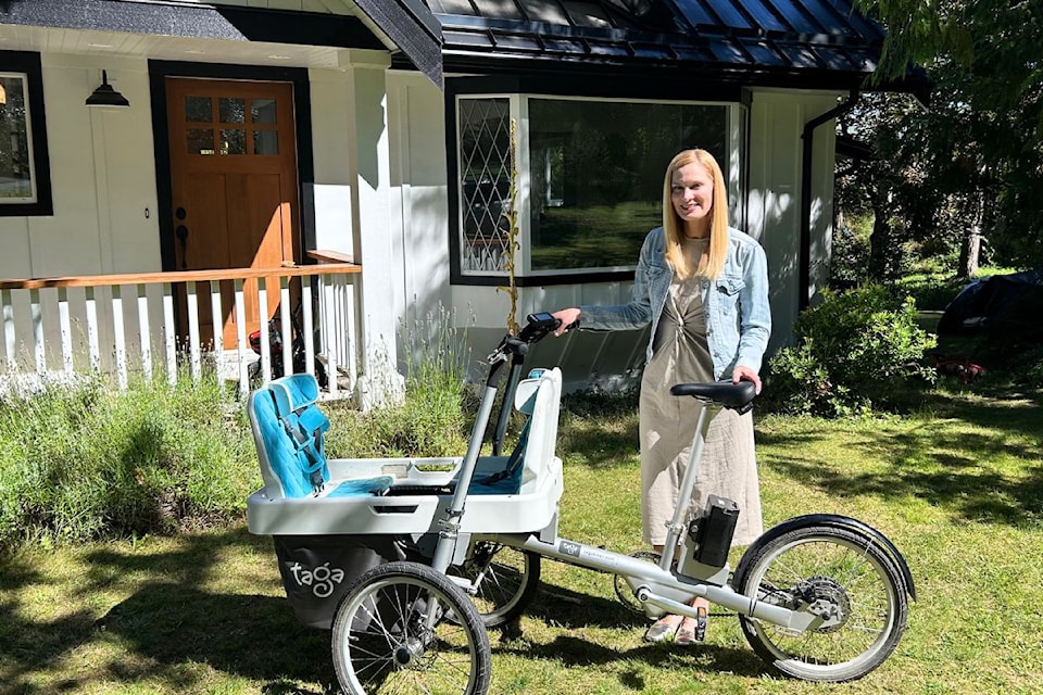 Sarah Riddell stands outside her home in Brentwood Bay with her cargo bike which she uses to take her kids to school. Riddell says having affordable childcare a few kilometres from her house accessible by bike is a positive outcome she's seen with the NDP government.