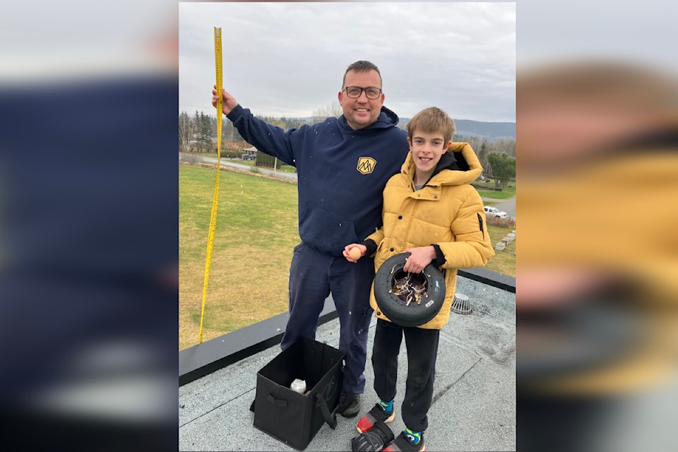 Brian Ens (left) and Parker Johnson (right) on the roof of Lakeview Elementary in Quesnel where Parker did the official drop of his egg-protecting device, which is made from a go-kart tire.