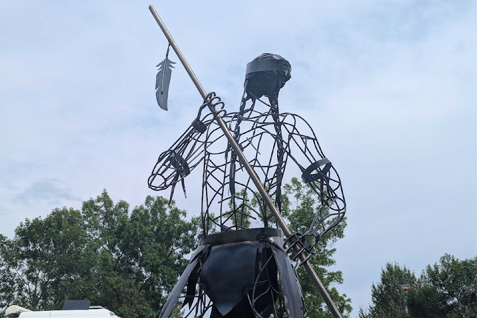 The fisherman statue now stands among a group of metal salmon in Lhtako Dene Park.