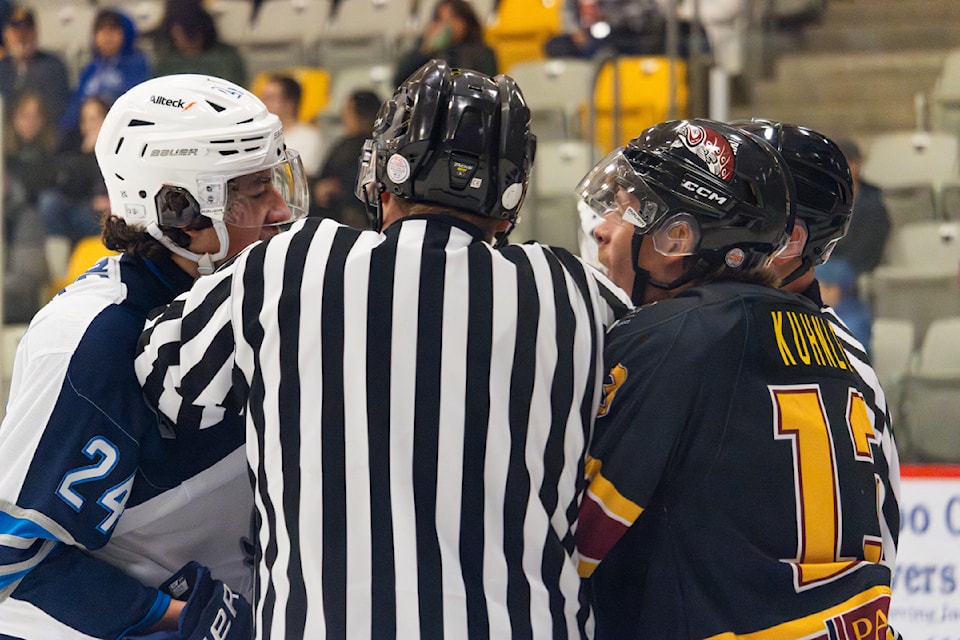Bennett Kuhnlein and a Mustangs player chirp at each other as a ref attempts to break them up.