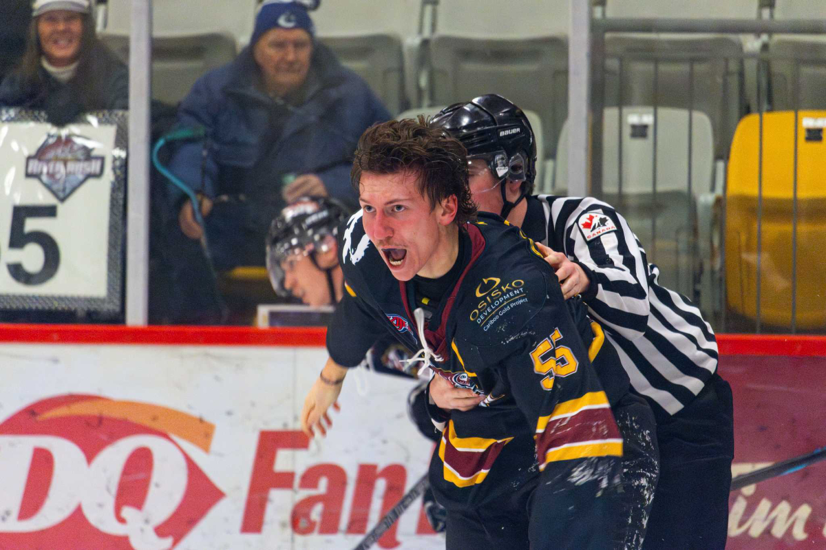 Richard Burden is taken off the ice by a ref.