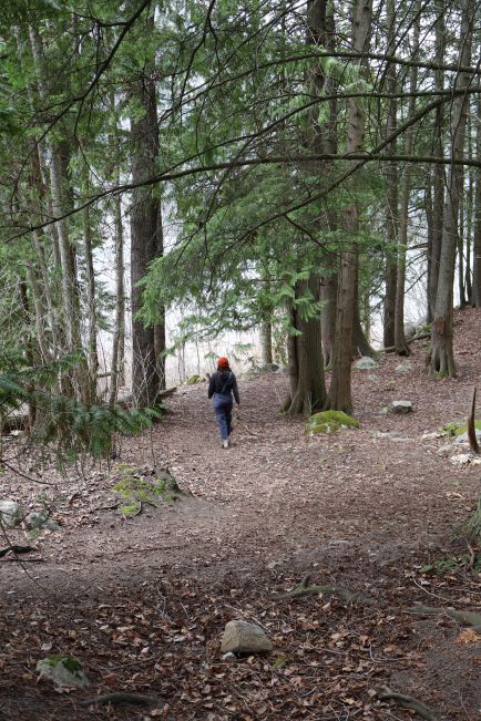 Gracie Smith walks through a forested area.