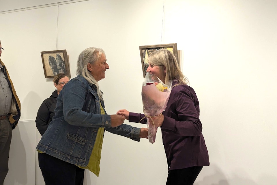 Cecile Allen receives flowers during her discussion of the art show.