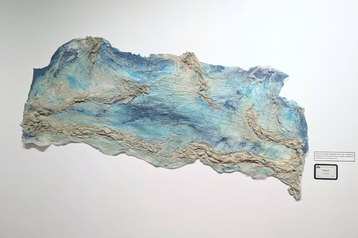 A piece of art sculpted from fabric that's been hardened and formed into a pattern representing water.
