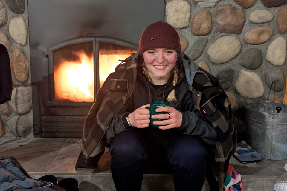 Savannah Robinson warming up in the Hallis Lake lodge after spending 24 hours skiing in lows of -21 and enduring fresh snowfall throughout the night.