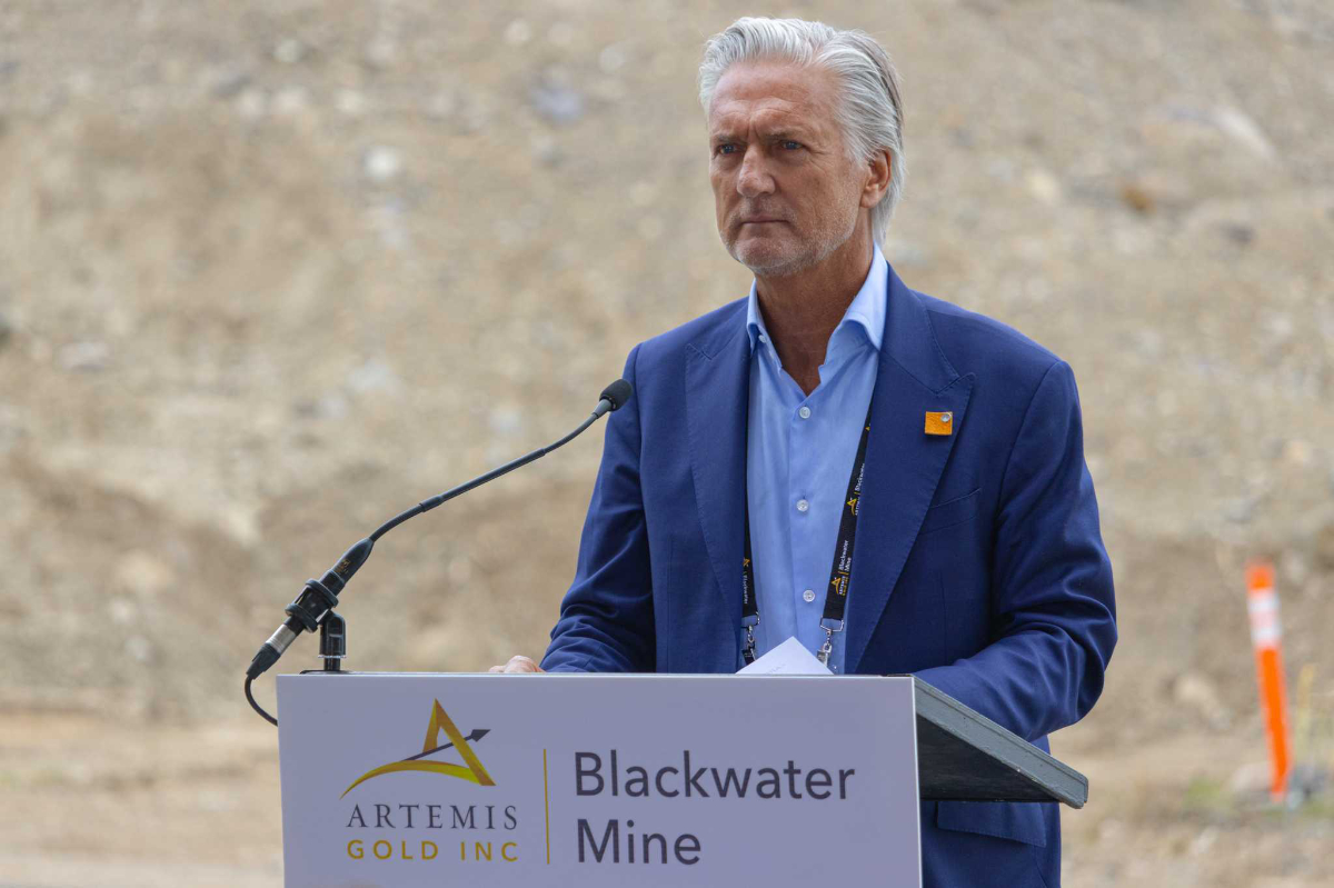 Artemis Gold CEO Steven Dean stands at a podium, prepared to speak