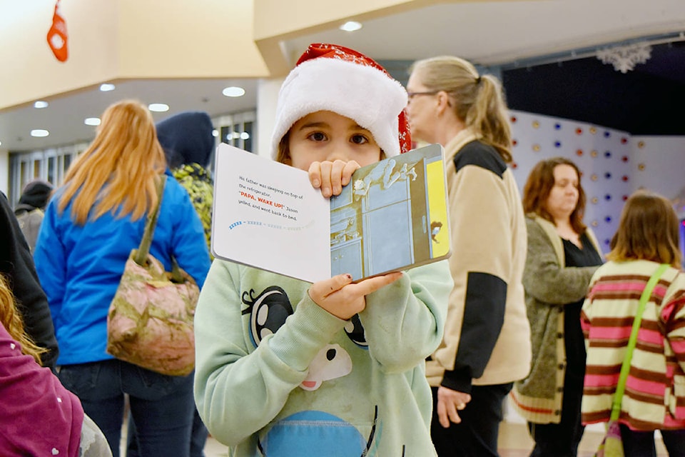 A young reader holds up the book she’s perusing. Heather Norman photos