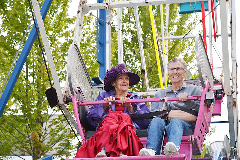 Joey Stromquist (left) and Marj Blackstock ride the Ferris wheel Thursday morning. The Billy Barker Days Society and Shooting Star Amusements offered free Ferris wheel rides to seniors in honour of Gloria Lazzarin, a former Quesnel city councillor and Cariboo Regional District director who died this winter. Lazzarin used to ride the Ferris wheel every year. Lindsay Chung photo