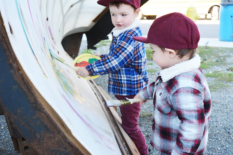 Brothers Finnigan (left, 18 months) and Calvin Wurm, 3, paint an Emcon Services snowplow during Touch A Truck.
