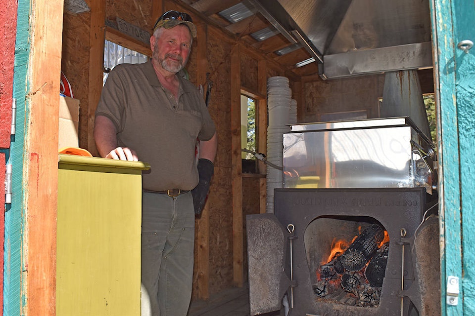 Ted Traer stands by his wood-fired evaporator as he processes birch sap into syrup. The evaporator came from a maple syrup producer in Quebec. (Rebecca Dyok photo)