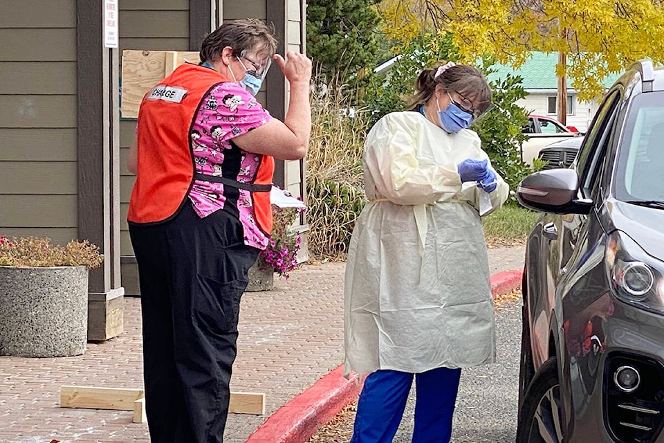 Debbie Fadenrecht gives a ‘whoop, whoop’ and a thumb’s up to residents who are vaccinated, as they line up for COVID testing Friday, Sept. 24. (Angie Mindus photo - Williams Lake Tribune)