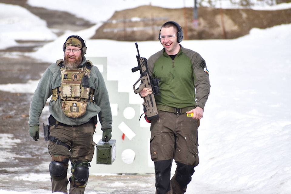 Shawn Leaf walks off the range with Thomas Simpson after having completed a stage in the 2Gun Winter Brutality Competition. (Rebecca Dyok photo — Quesnel Cariboo Observer photo)
