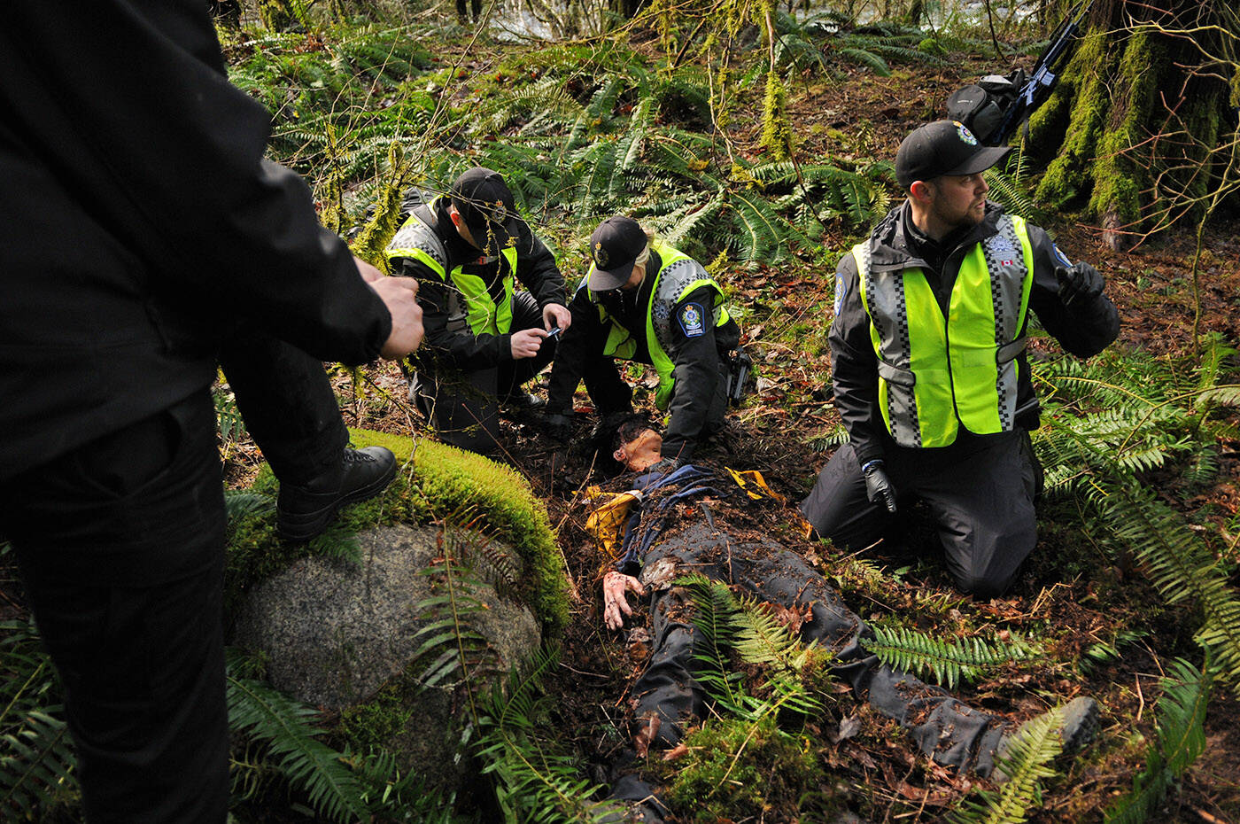 Conservation officers take part in a wildlife attack training scenario in Chilliwack on Thursday, March 3, 2022. Mannequins, like the one lying on the ground, are used as victims of the fatal attacks. (Jenna Hauck/ Chilliwack Progress)