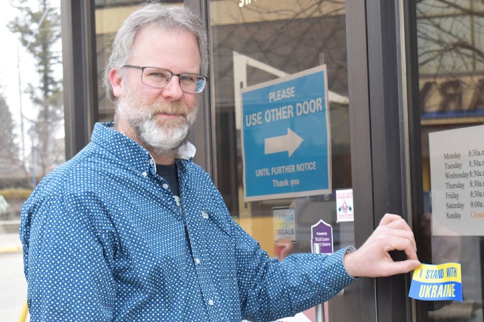 Big Country Printers Ltd. in downtown Quesnel has started to print decals to support Ukrainian refugee relief. Owner Gilbert Schotel applied one to their door Thursday, March 10. (Rebecca Dyok photo — Quesnel Cariboo Observer)