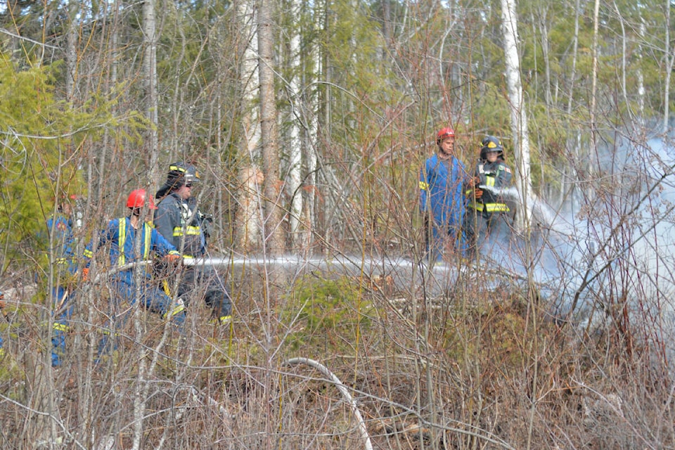 Firefighters team up to target the same hotspot while responding to a grassfire on the Quesnel-Hydraulic Road. (Cassidy Dankochik Photo - Quesnel Cariboo Observer)