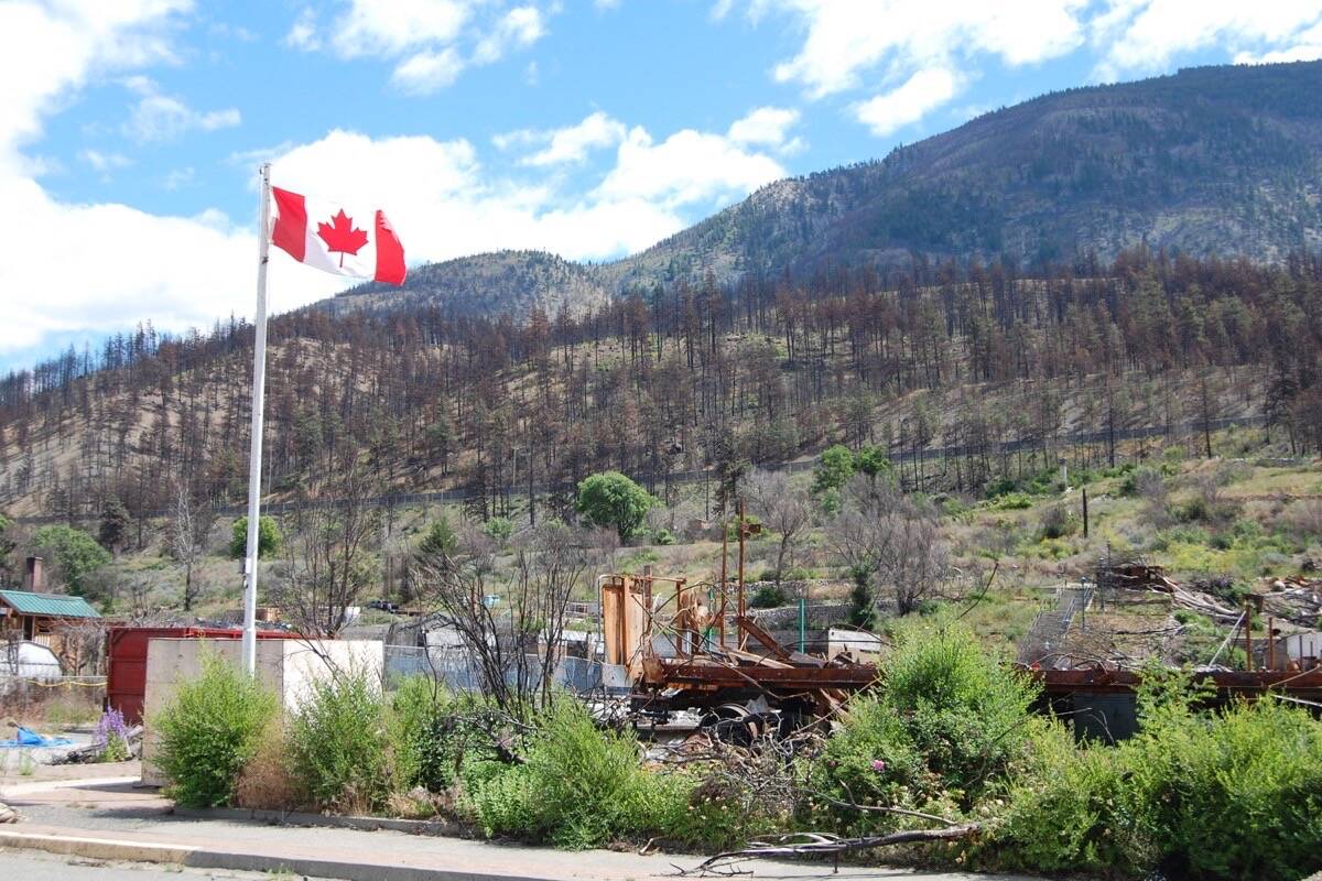 Members of the Royal Canadian Legion in Lytton have installed a new flag beside the site of the Legion building on Fraser Street. Work on clearing the property has yet to start. (Photo credit: Barbara Roden)