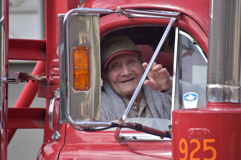 Ray Collins, 96, waves from his “Ol Red” Mack logging truck. Collins owned one of the first logging companies in Quesnel, and bought “Ol Red” new in 1960 with a self-loading trailer for $23,000. (Rebecca Dyok photo — Quesnel Observer)