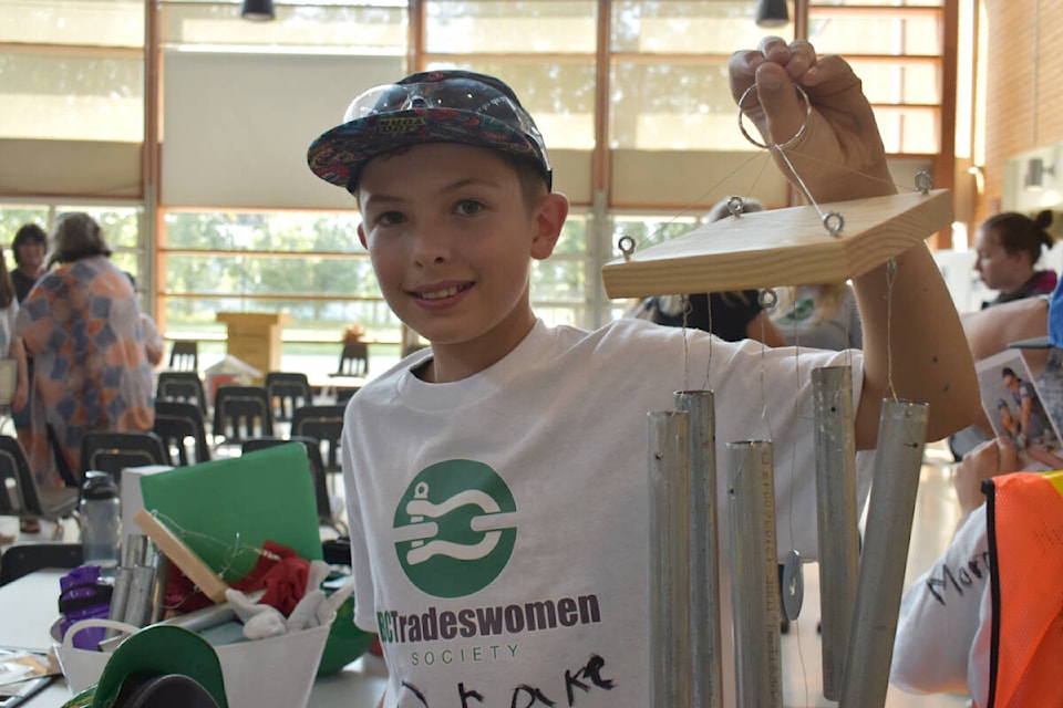 Zander Kopetski, 11, holds up an EMT wind chime they made at the Discover Trades Day Camp. (Rebecca Dyok photo — Quesnel Observer)