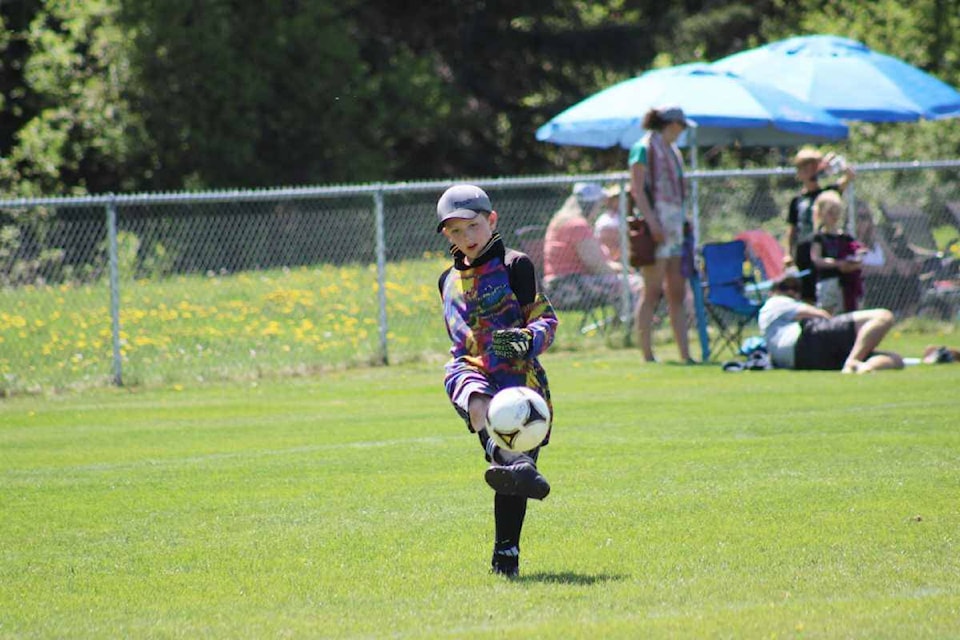 100 Mile House U11/12 goalie Wyatt Geddert kicks the ball back into play in a game with Quesnel at the Cariboo Youth Soccer league tournament held May 28 in 100 Mile House. (Fiona Grisswell photo - 100 Mile Free Press)