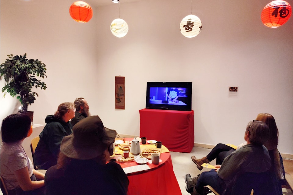 Joni Cheung and people attending the show's opening watch an episode of Soba's Corner.